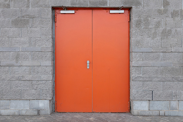 gray-brick-wall-with-wide-bright-orange-door-in-th-2023-11-27-04-58-43-utc